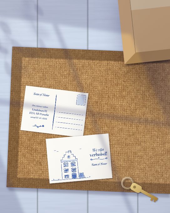 Twee verhuiskaarten van Sam & Noor op de deurmat in de gang, een verhuisdoos en de nieuwe sleutels ernaast: een grachtenpand in Delfts blauw en “We zijn verhuisd!” op de voorkant, een nieuw adres op de achterkant. Een mockup, geen foto.